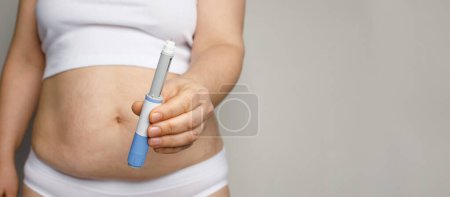 Concepto de semaglutida y pérdida de peso. Mujer que muestra pluma de inyección de semaglutida o pluma de cartucho de insulina. 