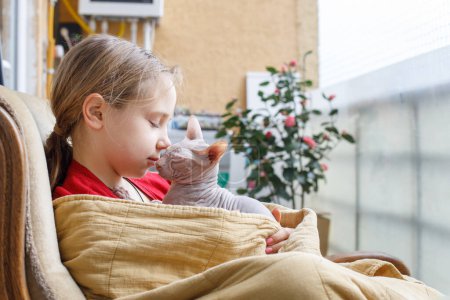 Mignon enfant fille et chat animal de compagnie sur le balcon
