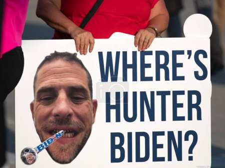 Photo for Milwaukee, Wisconsin, USA - August 23, 2023: A supporter of former President Donald Trump holds a Hunter Biden protest sign at the entrance to the first 2024 Republican Presidential Debate. - Royalty Free Image
