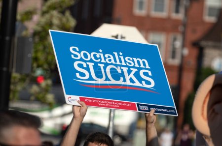 Photo for Milwaukee, Wisconsin, USA - August 23, 2023: A protester holds a socialism sucks sign at the entrance to the first 2024 Republican Presidential Debate. - Royalty Free Image