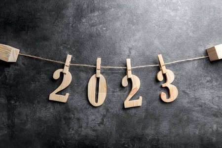 Photo for 2023 hanging on a clip on the rope with a black background. Happy New Year 2023 - Royalty Free Image