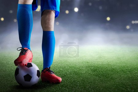 Photo for Football player man in a blue jersey standing with the ball on the football field - Royalty Free Image