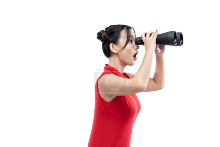Foto de Asian Chinese woman in a cheongsam dress looking through binoculars isolated over white background - Imagen libre de derechos