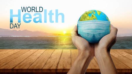 Photo for Human hand showing earth with a face mask. World Health Day Concept - Royalty Free Image