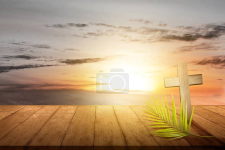 Cross and palm leaf with sunset scene background. Palm Sunday Concept