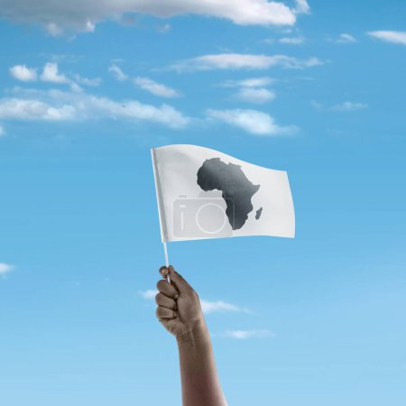 Foto de Una mano humana sosteniendo una bandera con mapas africanos con un fondo de cielo azul. África concepto de día - Imagen libre de derechos
