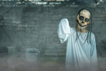 Scary Momo standing in the graveyard with a dark background. Scary face for Halloween. Halloween concept