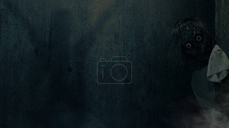 Téléchargez les photos : Momo effrayant debout derrière le mur avec un fond sombre. Visage effrayant pour Halloween. Concept Halloween - en image libre de droit