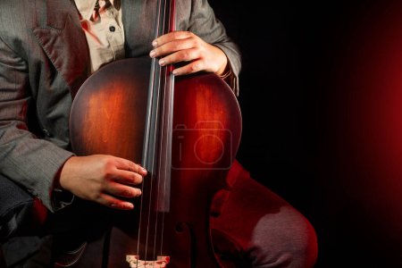 Téléchargez les photos : Musicien jouant du violoncelle. Violoncelliste ou violoncelliste jouant avec un fond noir - en image libre de droit