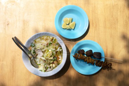 Photo for Chicken soup (Soto Ayam) with intestine and liver satay is ready to serve. Traditional Indonesia food - Royalty Free Image