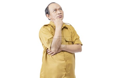 Photo for Civil servant man standing while thinking something isolated over a white background. Pegawai Negeri Sipil (PNS) - Royalty Free Image