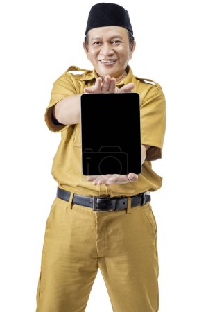 Photo for A civil servant man holding and showing a blank tablet screen isolated over a white background. Pegawai Negeri Sipil (PNS) - Royalty Free Image