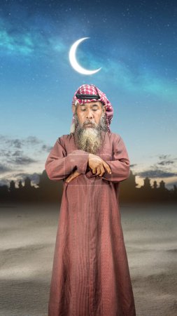 A Muslim man with agal in a praying position (salat) with a night scene background. Muslim concept