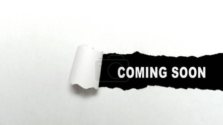 Papier déchiré avec texte "à venir bientôt" avec un fond noir. Nouveau concept