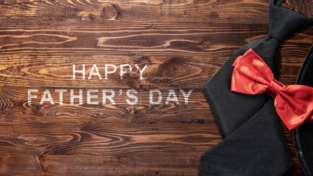 Téléchargez les photos : Chapeau noir et noeud papillon rouge avec un message de fête des pères heureux. Concept de fête des pères - en image libre de droit