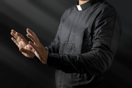 Foto de Retrato de un pastor dando un sermón sobre un fondo negro. Concepto cristiano - Imagen libre de derechos