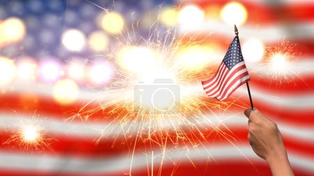 Téléchargez les photos : Vue rapprochée d'une main humaine tenant le drapeau américain avec un fond de feu d'artifice. Concept du 4 juillet - en image libre de droit
