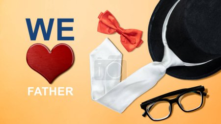 Foto de Black hat and red bow tie with eyeglasses and a red heart with We Love Father's text. Fathers day concept - Imagen libre de derechos
