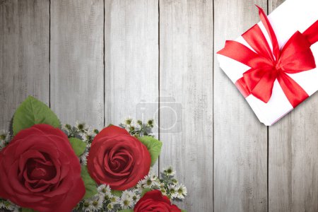 Foto de A gift box and a flower bouquet on a wooden table. Congratulation concept - Imagen libre de derechos