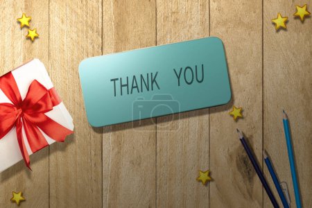 Photo for Gift box with Thank You text on the mobile phone screen on a wooden table. Thank you concept - Royalty Free Image