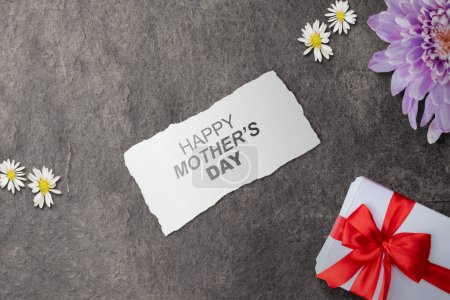 Foto de Papel con texto del Día de la Madre Feliz y una caja de regalo sobre un fondo negro. Concepto del día de las madres - Imagen libre de derechos