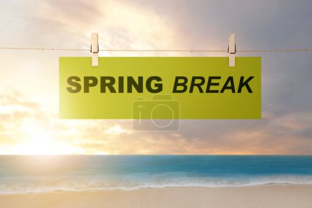 Papier hängt am Seil mit Spring Break Text am Strand. Frühjahrspause-Konzept