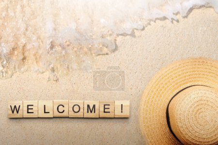 Photo for A row of wooden cubes with welcome text with a sandy beach background. Introduction concept - Royalty Free Image