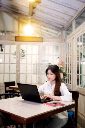 Foto de Retrato de una mujer de negocios usando su portátil mientras trabajaba en la cafetería - Imagen libre de derechos