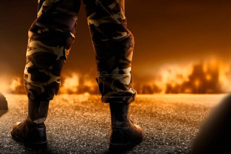 Foto de Pies de soldado con botas militares de pie con fuego y explosión en el fondo de la escena de guerra - Imagen libre de derechos