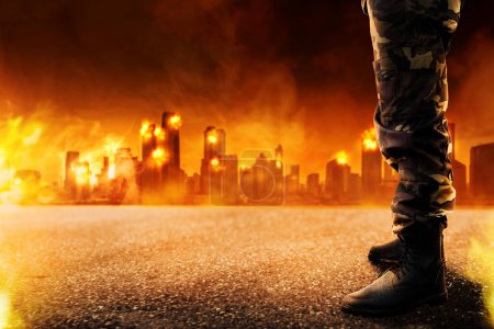 Foto de Image of demolished city in  from military aggression at night with fire and appearance of an army boots appearance. Smoke and fire from skyscarper at downtown from terorism attack. - Imagen libre de derechos