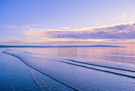 Foto de The headlands of Ayr in the far distance almost in silhouette and from Troon bay with reflections on the water - Imagen libre de derechos