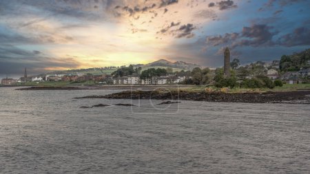 Photo for Scottish Town of largs Looking North Past the Pencil Monument with the sun going down behind Knock Hill in the far Distance. - Royalty Free Image