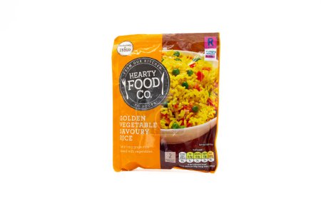 Foto de Irvine, Scotland, UK - February  02, 2023: Tesco branded Hearty Food Co golden vegetable savoury rice In packaging displaying graphics and energy icons relevant to the product and taken against a white background. - Imagen libre de derechos