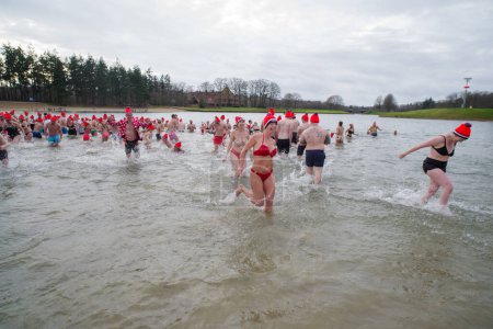 Foto de OLDENZAAL, NETHERLANDS - JANUARY 1, 2023: People running into the water at the traditional new years dive - Imagen libre de derechos