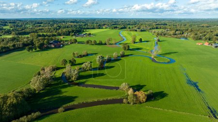 Foto de Vista aérea de un hermoso paisaje verde con un pequeño río que fluye a través. Se encuentra en la parte oriental de los Países Bajos - Imagen libre de derechos