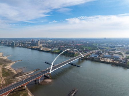 aerial view of a modern bridge called "De Oversteek" (the Crossing) in Nijmegen, the Netherlands. It crosses the Waal river