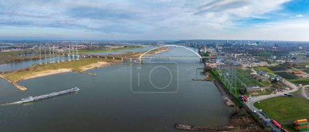 aerial view of a modern bridge called "De Oversteek" (the Crossing) in Nijmegen, the Netherlands. It crosses the Waal river