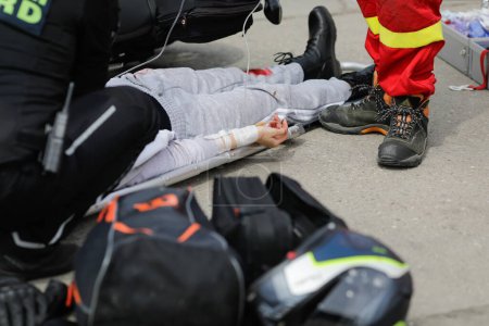 Téléchargez les photos : Otopeni, Roumanie - 15 mai 2023 : Les premiers intervenants roumains, les pompiers et les ambulanciers paramédicaux, s'entraînent pour sortir et sauver la victime d'un accident de moto lors d'un exercice de forage. - en image libre de droit