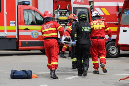 Foto de Otopeni, Rumania - 15 de mayo de 2023: Primeros auxilios, bomberos y paramédicos rumanos, entrenan para rescatar y salvar a la víctima de un accidente de motocicleta durante un ejercicio de perforación. - Imagen libre de derechos