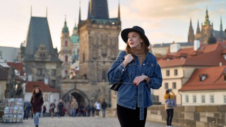 Foto de Elegante joven hermosa mujer con sombrero negro en Praga en el fondo. Elegante retro dama retrato de arte. - Imagen libre de derechos