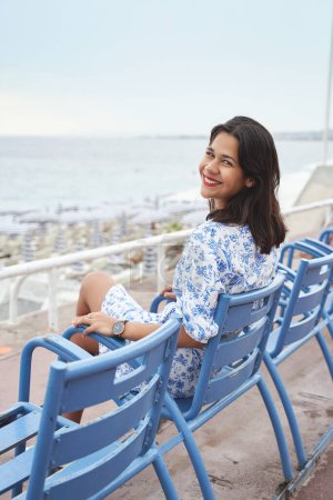 Téléchargez les photos : Belle jeune femme souriante métissée sur la Promenade des Anglais à Nice, France - en image libre de droit