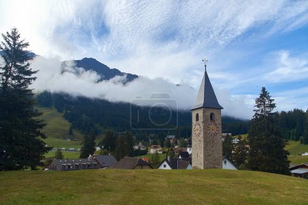 Foto de Hermosa campiña alpina suiza con un campanario medieval y montaña Rothorn en el fondo en el pueblo de Churwalden en Suiza. Anteriormente Parpan - Imagen libre de derechos