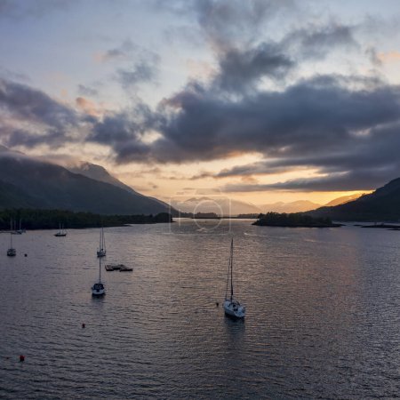 Foto de Mirando al oeste a lo largo del lago leven a ballachulish al atardecer vista elevada con veleros amarrados - Imagen libre de derechos