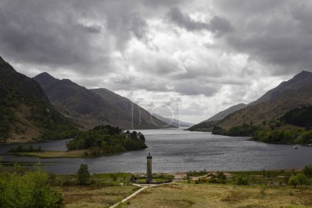Téléchargez les photos : Glenfinnan monument et loch bouclier avec des nuages orageux - en image libre de droit