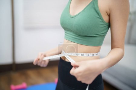 Foto de Mujer asiática con anorexia con cinta métrica sintiéndose infeliz. Problema de anorexia percepción corporal y dismorfia - Imagen libre de derechos
