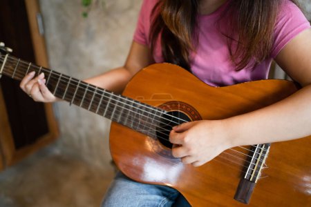 Téléchargez les photos : Heureuse jeune femme mains jouant de la guitare acoustique musicien seul composer sans son instrumentale sur le jeu de la guitare. - en image libre de droit
