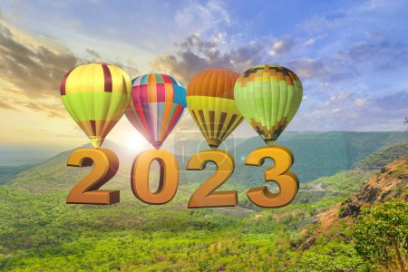 Téléchargez les photos : Nouvelle année 2023 concept. Texte 2022 accroché à la montgolfière au coucher du soleil. Nouvel An début - en image libre de droit