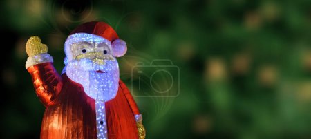 Téléchargez les photos : Gros plan d'une Santa Clause sur fond bokeh vert avec tourbillon floral. Salut de Noël. Espace de copie. - en image libre de droit