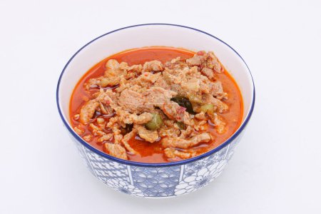 Téléchargez les photos : Panaeng Curry au porc. Trancher M en pâte de curry rouge et lait de coco dans un bol sur un fond blanc isolé. De la nourriture thaïlandaise. Vue du dessus. - en image libre de droit