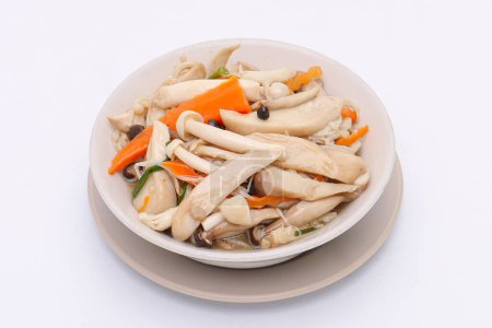 Téléchargez les photos : Champignon frit avec sauce soja dans un plat blanc sur fond blanc isolé. De la nourriture thaïlandaise. Vue du dessus. - en image libre de droit